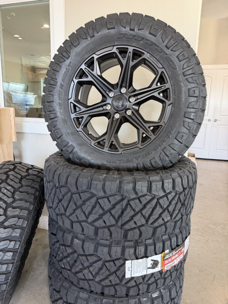 Fuel Off-Road wheel and tire displayed in front of a stack of tires.
