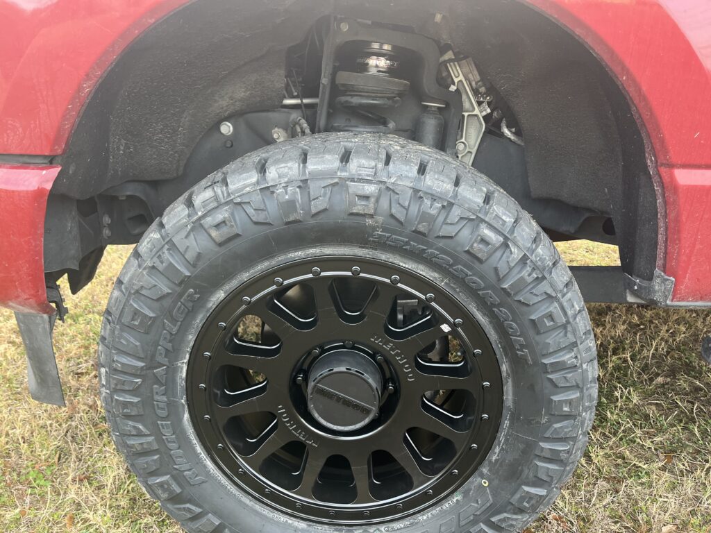 Close-up of a Method wheel installed on a red truck.